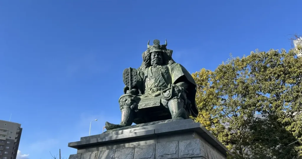 甲府駅前の武田信玄公銅像は、甲斐の名将として知られる信玄の威厳ある姿を表現した像です。卓越した軍略と政治手腕で領国を発展させた功績をたたえ、多くの人々に親しまれています。